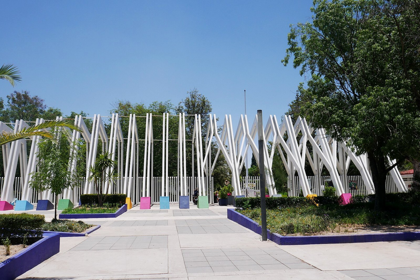 Entrada principal del Parque Rodolfo Landeros (Parque Héroes) en Aguascalientes, con la pérgola blanca y andadores